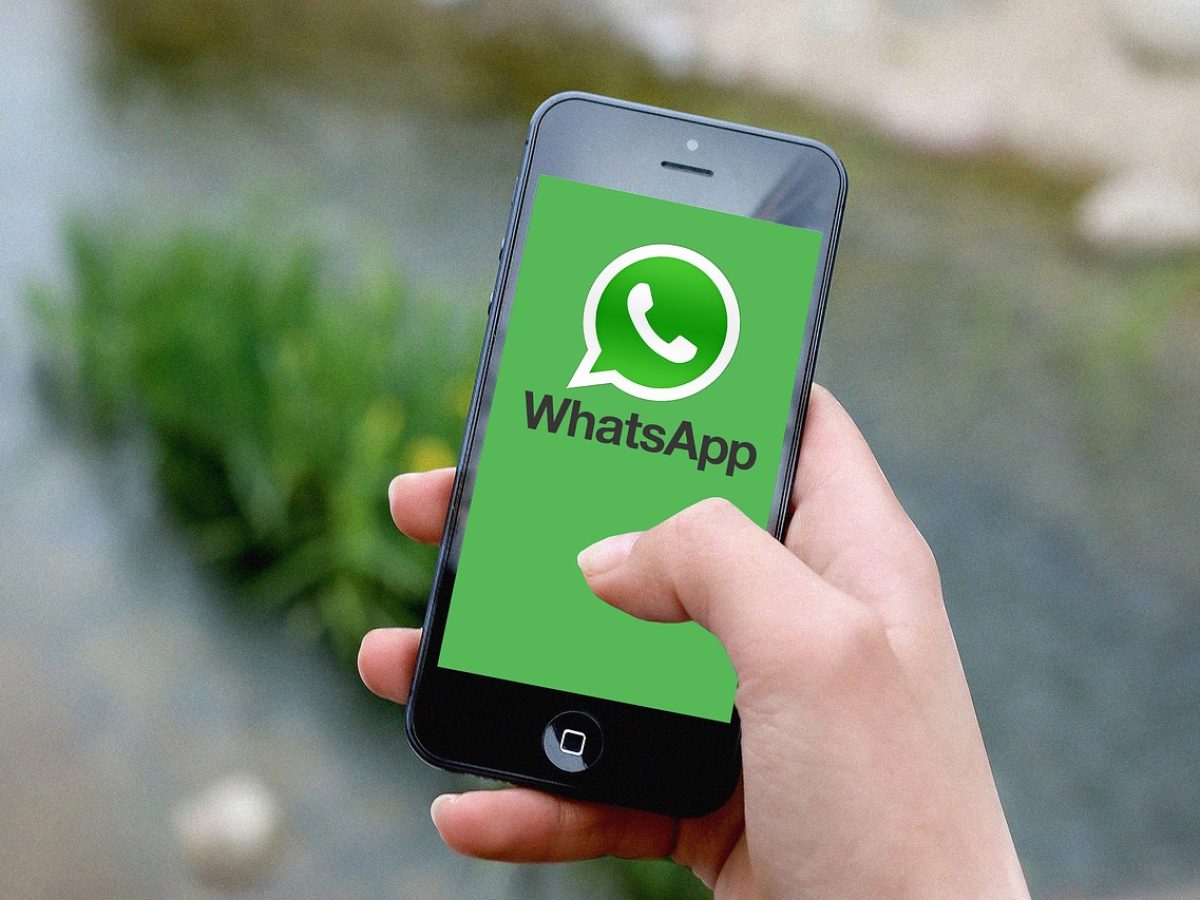 黑色 App 主视觉：深色背景上悬浮一部手机，屏幕显示黑色单品清单与搭配比例环形图，旁侧散落几片深色布料样本，整体氛围沉静克制